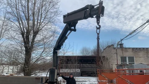 Construction worker operating crane mounted on a truck at a construction site. Stock Footage 301503426