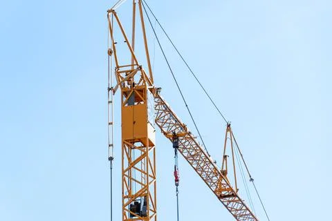 Construction worker operating crane in urban area during day Stock Photos