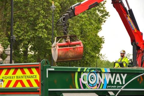 Construction worker operating a lorry mounted crane Stock Photos