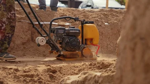 Construction worker operating vibratory plate compactor Stock Footage 341294853