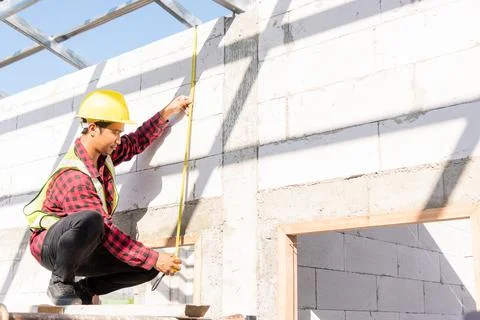 Construction worker or contractor man using measuring tape checking from stee Stock Photos