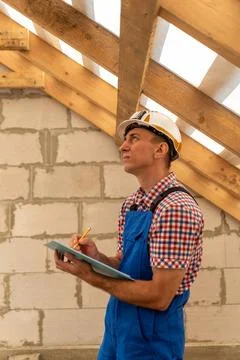 Construction worker or engineer inspecting a residential roof structure and.. Stock Photos