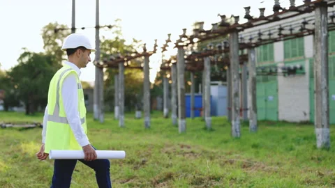 Construction worker or engineer wearing a helmet and safety vest walking near Stock Footage 194622873
