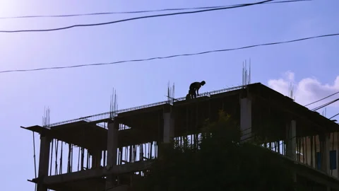 Construction worker or laborer working on a roof top of a incomplete buildin Stock Footage 287536581