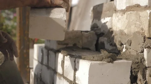 Construction worker or mason laying bricks and creating walls. Bricklayer laying Vidéo 132834327