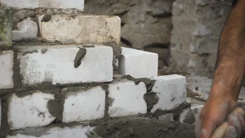 Construction worker or mason laying bricks and creating walls. Bricklayer laying Stock Footage 136295076