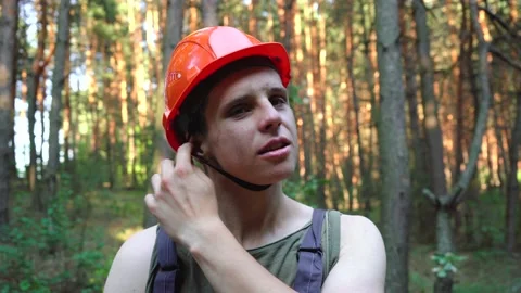 Construction worker in an orange helmet stands in the woods Stock Footage 140378796