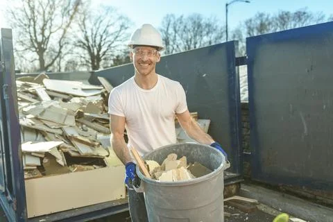 Construction Worker outside of house put old renovation material on big Фото