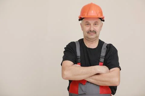 Construction worker in overalls and hard hat. Repairman with a mustache worke Stock Photos