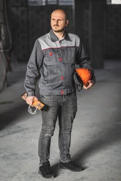Construction worker in overalls, with a helmet, a construction level and safety Stock Photos