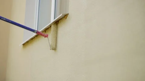 Construction worker painting a wall with a paint roller. Stock Footage 283908447