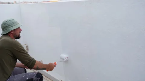 Construction worker performs exterior renovation by applying protective coa.. Stock Footage 334550827