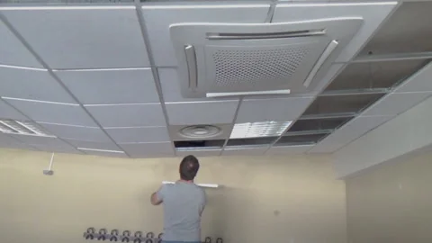 Construction worker performs a suspended ceiling maintenance with mineral fib Vídeo Stock 140128282