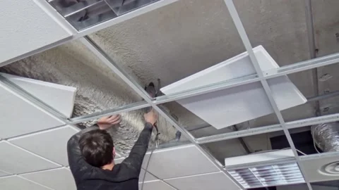 Construction worker performs a suspended ceiling maintenance with mineral fib Video stock 205892749