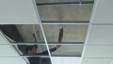 Construction worker performs a suspended ceiling maintenance with mineral fib Video stock 232239196