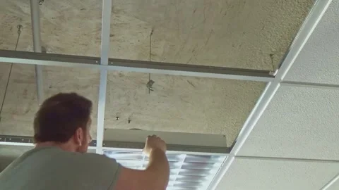Construction worker performs a suspended ceiling maintenance with mineral fib Vídeos de archivo 279383774