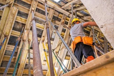 Construction Worker Performs Tasks on a High-Rise Building Site During Dayl.. Stock Photos