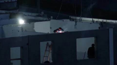 Construction worker performs welding operations on upper level of building frame 스톡 동영상 329213908