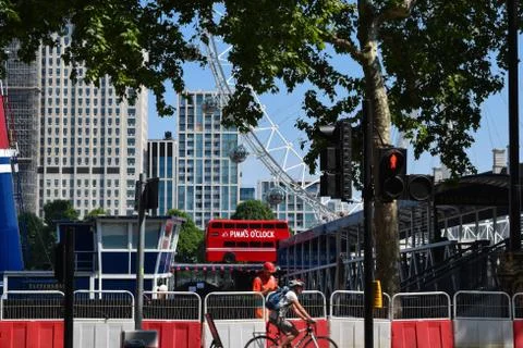 Construction worker on the phone while cyclist passes through in London from Stock Photos