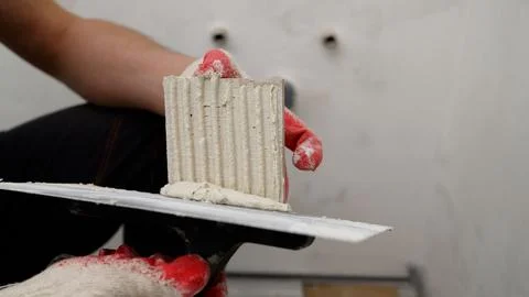 Construction worker picking up plaster with trowel Stock Photos