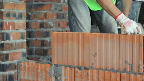 Construction worker placing brick on a wall, A construction worker in gloves and Stock Footage 281189713