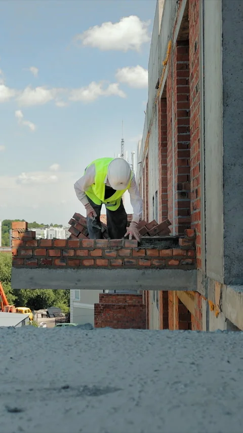 Construction worker placing bricks on an outdoor ledge. A construction worker Stock Footage 310307692