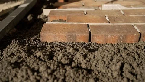 Construction worker placing bricks for patio paving Stock Photos