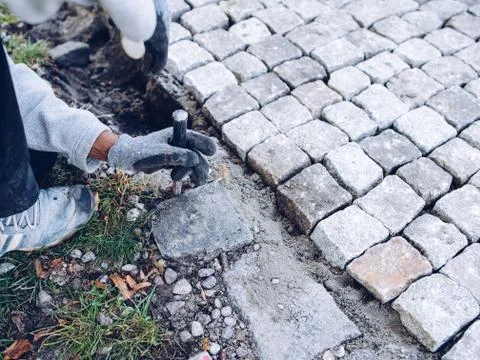 Construction worker placing stone tiles for pavement, terrace Stock Photos