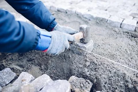 Construction worker placing stone tiles for pavement, terrace Stock Photos