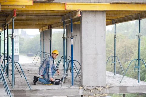 Construction worker planning project on concrete building floor Stock Photos