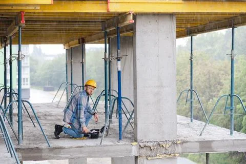 Construction worker planning project on concrete building floor Stock Photos