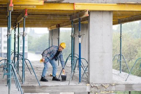 Construction worker planning project on concrete building floor Stock Photos