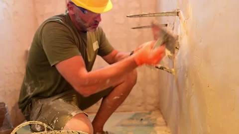 Construction worker plastering a bathroom wall during renovation work Video stock 346958842