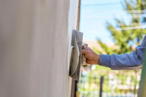 Construction worker plastering cement on wall. Stock Photos
