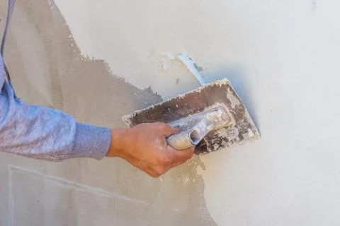 Construction worker plastering cement on wall. Stock Photos