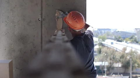 Construction worker plastering concrete wall on building site with trowel Stock Footage 318779647