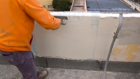 Construction worker plastering a wall with American trowel in hand Stock-Footage 84835133
