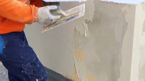 Construction worker plastering a wall with American trowel in hand Vídeo Stock 105880696