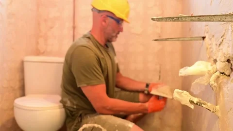 Construction worker plastering a wall with a trowel Video stock 346958831