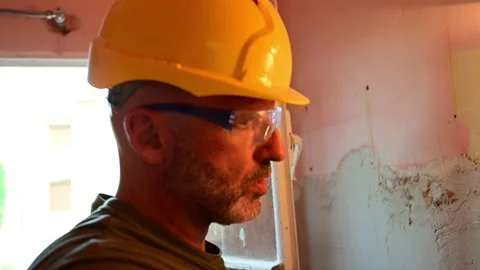 Construction worker plastering a wall with a trowel Stockbeeldmateriaal 346958833