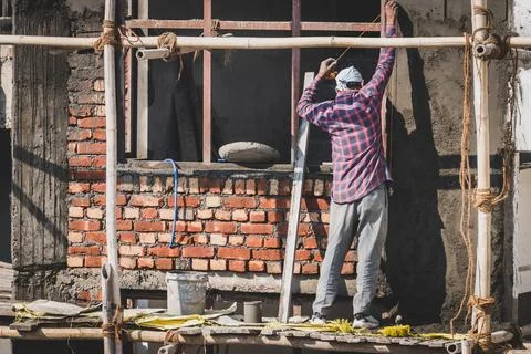 Construction worker plastering window panel ledge during residential house .. Stock Photos