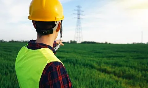 Construction worker pointing to the electricity pylon. Stock Photos