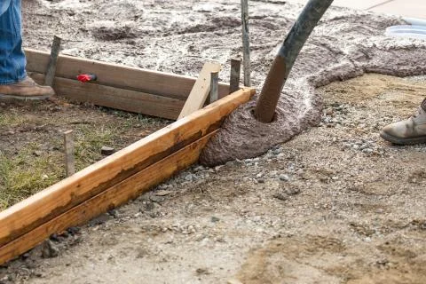 Construction Worker Pooring Wet Deck Cement Into Wooden Frame Foto stock
