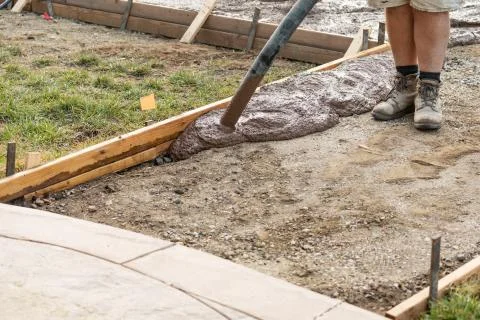 Construction Worker Pooring Wet Deck Cement Into Wooden Frame Foto stock