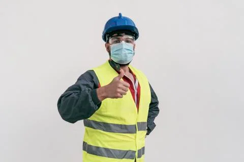 Construction worker portrait on white wall posing with face mask Stock Photos