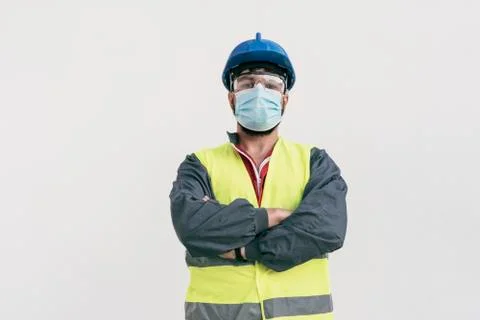 Construction worker portrait on white wall posing with face mask Stock Photos
