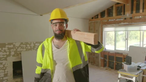 A Construction Worker Posing Confidently with Lumber in a Beautifully Renovated Stock Footage 306344215