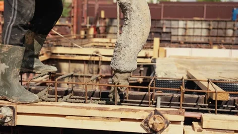 Construction worker pouring concrete into foundation formwork Stock Footage 341294507