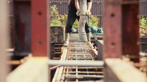 Construction worker pouring concrete into foundation formwork Stock Footage 341294588