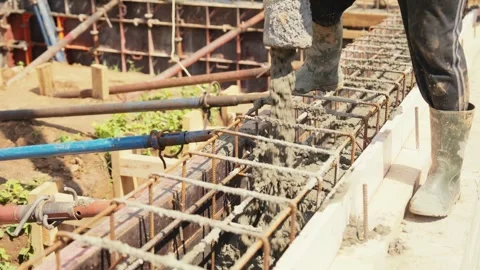 Construction worker pouring concrete into foundation formwork Stock Footage 341294812